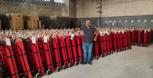 Rows of red fire extinguishers in a warehouse