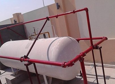 Red pipework around a storage tank